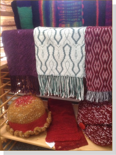 Knit and woven shawls, throws, hats, and clothing are available at Artisans United in Annandale.